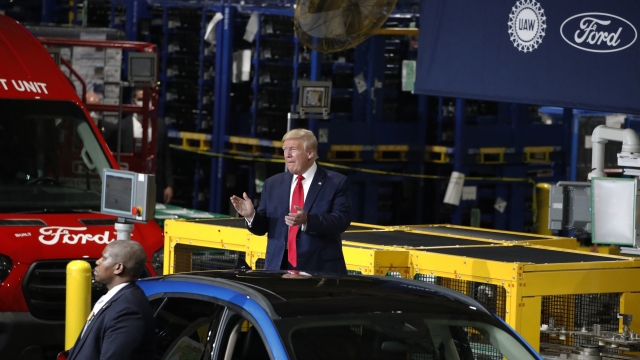 President Donald Trump claps as he walks to the podium to speak at Ford's Rawsonville Components Plant.