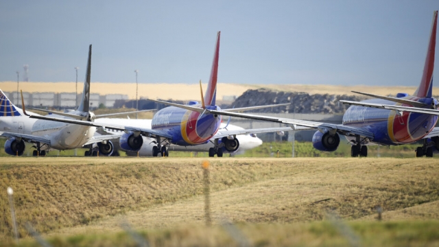 Jetliners taxi down a runway to take off from Denver International Airport.