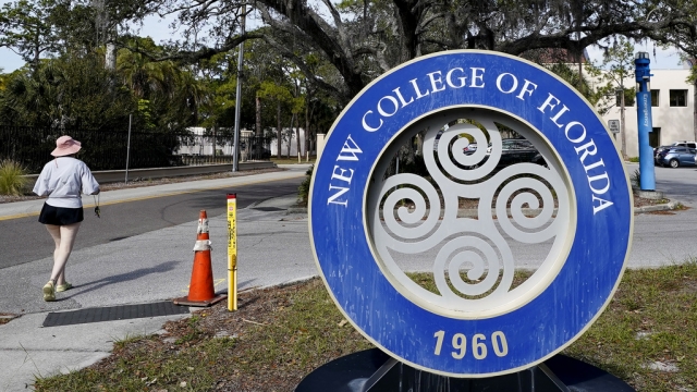 Student walks past the sign at New College of Florida.