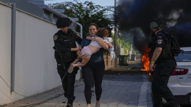 Israeli police officers evacuate a woman and a child from a site hit by a rocket fired from the Gaza Strip.