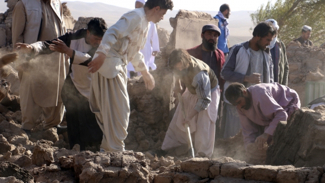 Afghan men search for victims after an earthquake in Zenda Jan district in Herat province