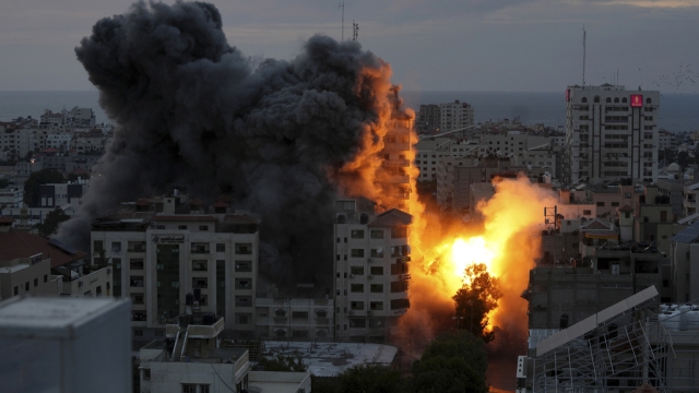A ball of fire and smoke rise from an explosion on a Palestinian apartment.