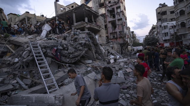 Palestinians look for injured in the rubble of a destroyed residential building