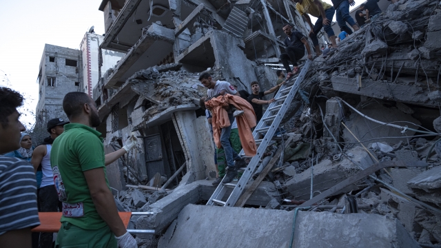 Palestinians rescue a young girl from the rubble of a destroyed residential building