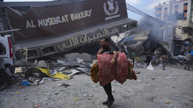 Palestinians walk past the Al Nuseirat Bakery, destroyed in an Israeli airstrike.