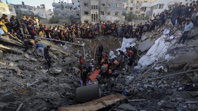 Palestinians gather over the remains of a destroyed house following Israeli airstrikes on Gaza City,