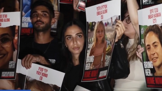 People hold up images of hostages in Gaza.