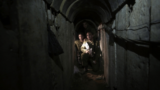 Israeli soldiers walk through a tunnel discovered near the Israel Gaza border