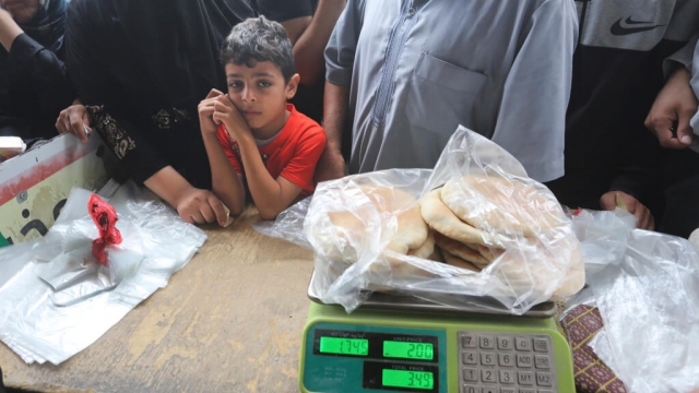 Palestinians wait to buy bread during the ongoing bombardment of the Gaza Strip in Rafah.