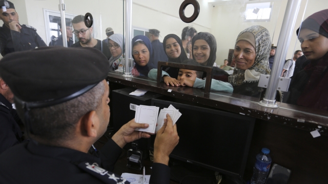 Palestinians with dual nationality register to cross from Gaza into Egypt.