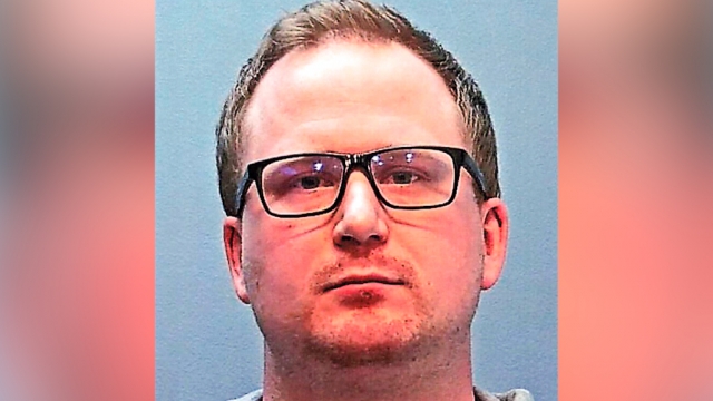A booking photo provided by the Police Department in Glendale, Colo., shows police officer Nathan Woodyard
