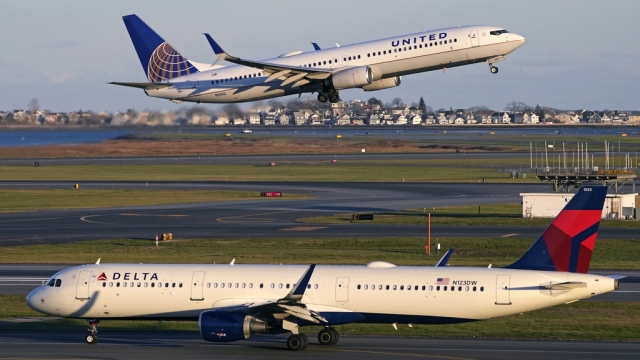 A United Airlines jet takes off while a Delta Airlines plane taxis at Boston Logan International Airport.