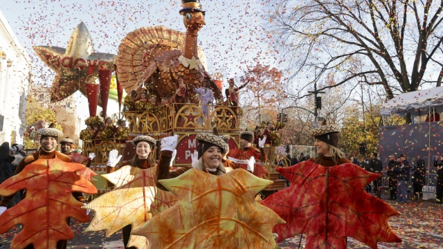 Parade performers lead the Tom Turkey float down Central Park West at the start of the Macy's Thanksgiving Day parade