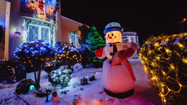 A home with outdoor Christmas lights and inflatable snowman.