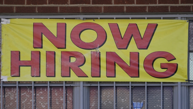 A downtown Jackson, Miss., business posts a large "Now Hiring" sign.