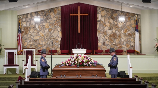 An honor guard from the Georgia State Patrol stand in a church at the casket before the funeral service for Rosalynn Carter