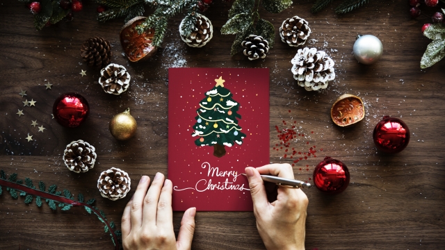 A person writing a Christmas card.