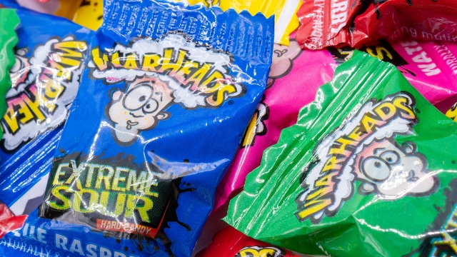 Warheads candies piled on top of each other in different colored wrappers