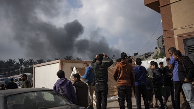 Palestinians look at smoke following an Israeli airstrike in Khan Younis, Gaza Strip.