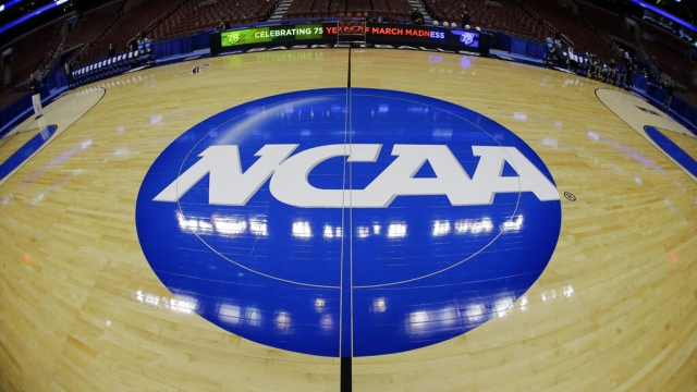 The NCAA logo on a college basketball court.