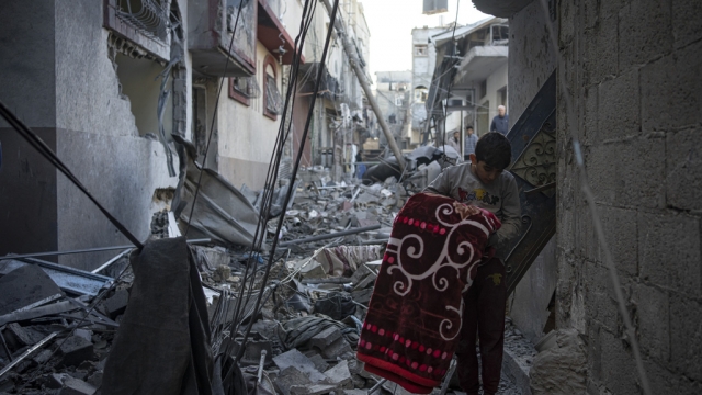Palestinians look at houses destroyed in the Israeli bombardment of the Gaza Strip in Rafah on Saturday, Dec. 9, 2023.
