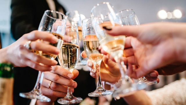 People celebrate and raise glasses of champagne.