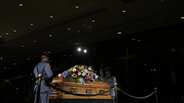A Georgia State Patrol honor guard stands as members of the public pay respects to former first lady Rosalynn Carter.