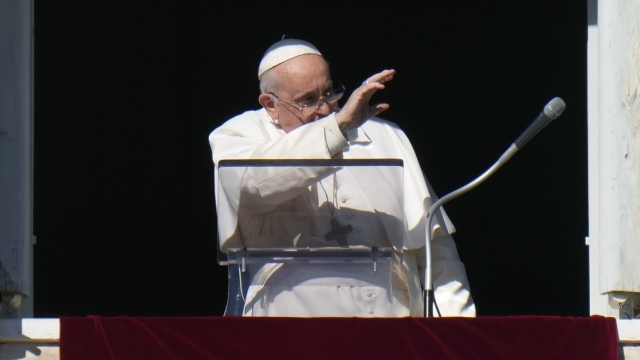 Pope Francis waves during the Angelus noon prayer from the window of his studio