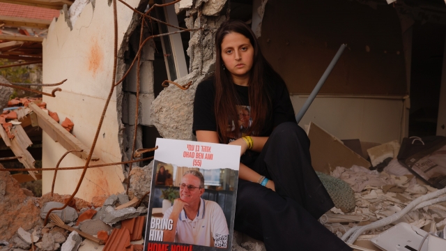 Ella Ben Ami holding a poster of her missing dad while returning to her Kibbutz 75 days after it was attacked by Hamas.