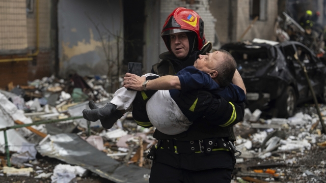 A firefighter carries a man from a damaged residential building after a Russian missile strike in Kyiv, Ukraine.