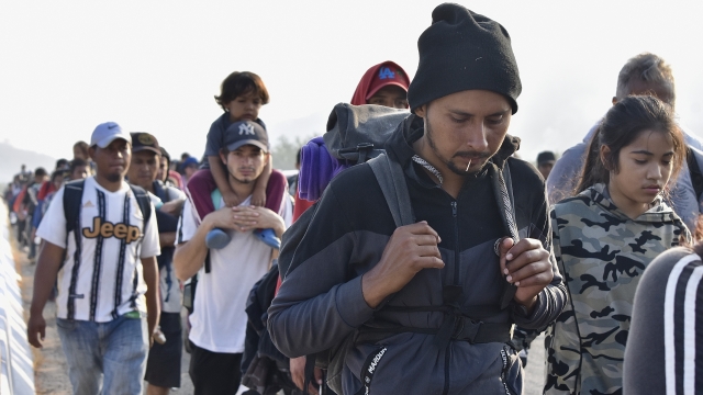 Migrants walk along the highway