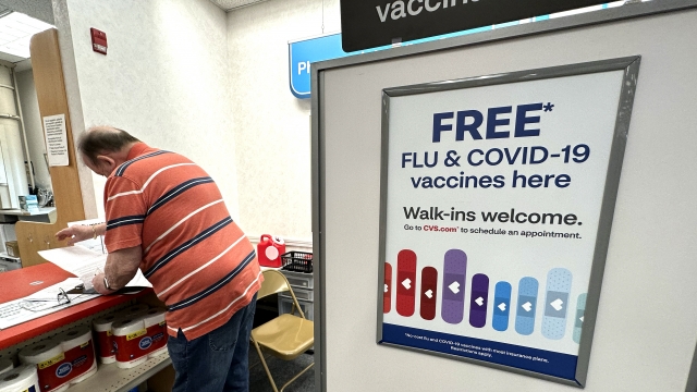 A sign for flu and covid vaccinations is displayed at a pharmacy store