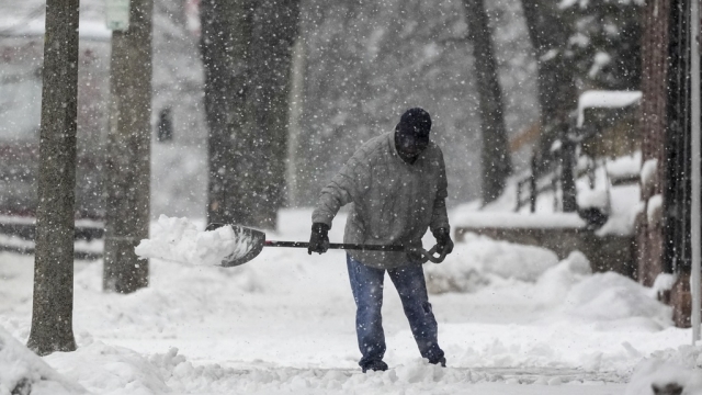 A man shovels as a winter storm arrives in the U.S.