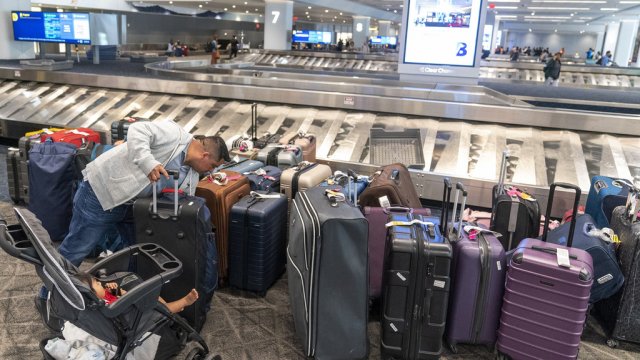 A traveler looks for his suitcase among the unclaimed luggage in the arrivals area of Terminal B at LaGuardia Airport.