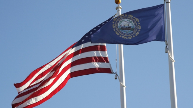The state flag of New Hampshire flies alongside the American flag.