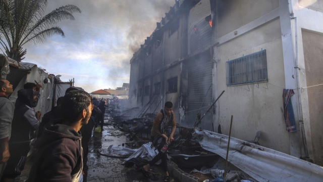 Palestinians try to extinguish a fire at a building of an UNRWA.