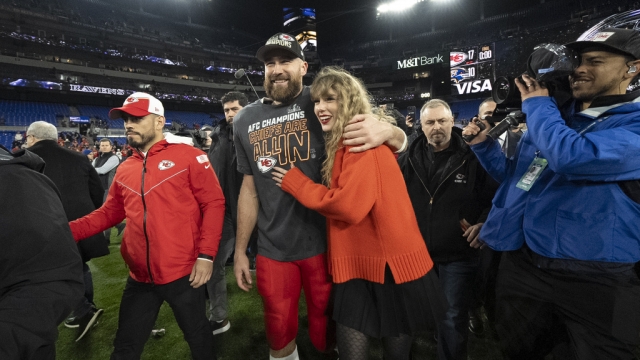 Travis Kelce and Taylor Swift walk together after the Kansas City Chiefs' won their final game before the Super Bowl.