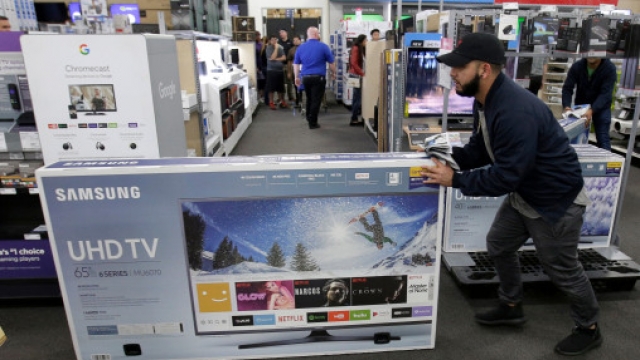 Jesus Reyes pushes a television down an aisle as he shops at a Best Buy store in Overland Park, Kansas