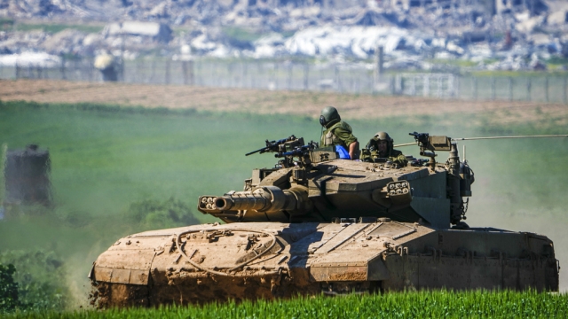 Israeli soldiers drive a tank on the border with the Gaza Strip.