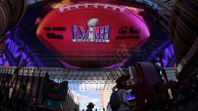 People cross a street at the Fremont Street Experience ahead of Super Bowl 58.