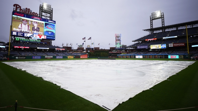 A tarp covers the infield as rain delays a baseball game between the Philadelphia Phillies and the Atlanta Braves.