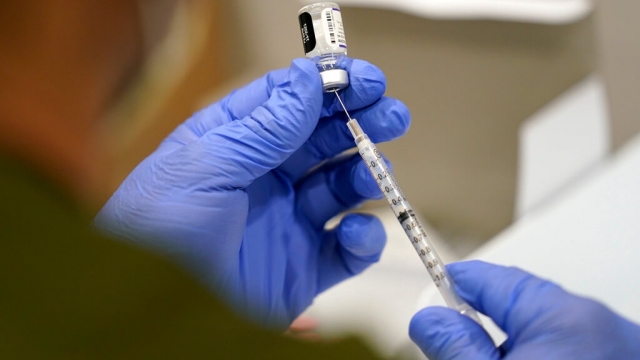 A health worker draws a dose of COVID-19 vaccine