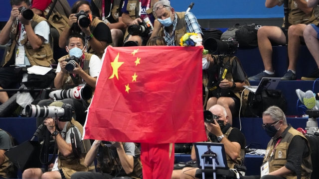 A Chinese flag is unfurled on the podium of a swimming event final at the Summer Olympics in Tokyo in 2021.