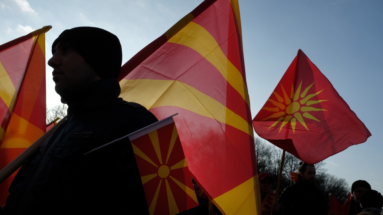 Macedonians hold Macedonian flags during a protest