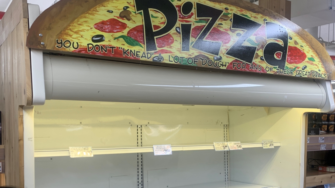 Empty shelves of a frozen pizza display
