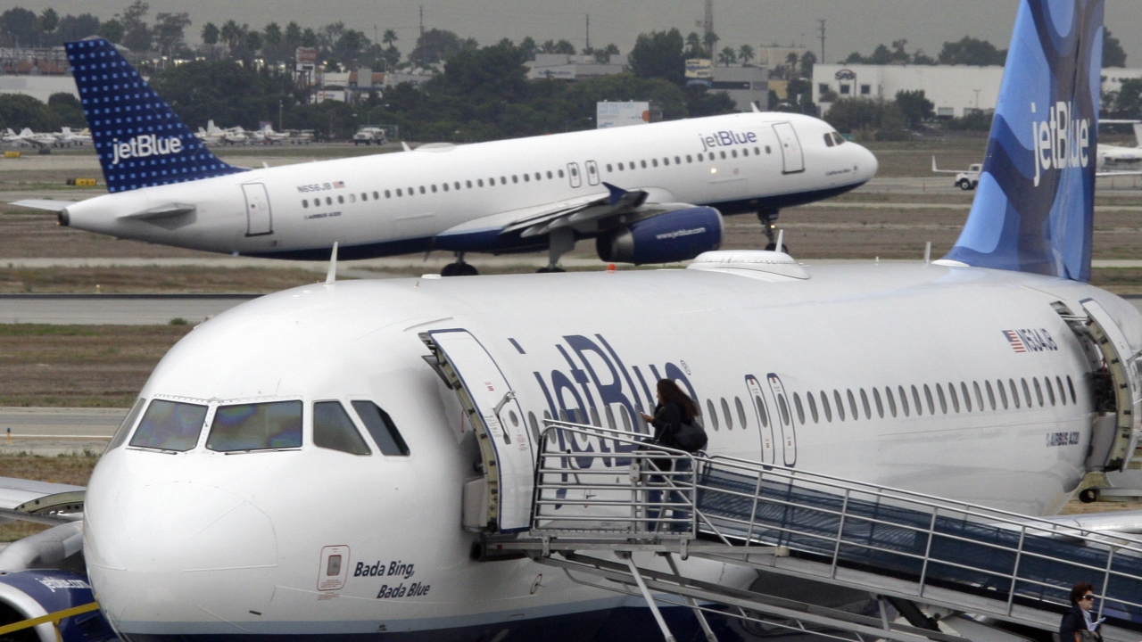 A passenger boards a JetBlue plane.