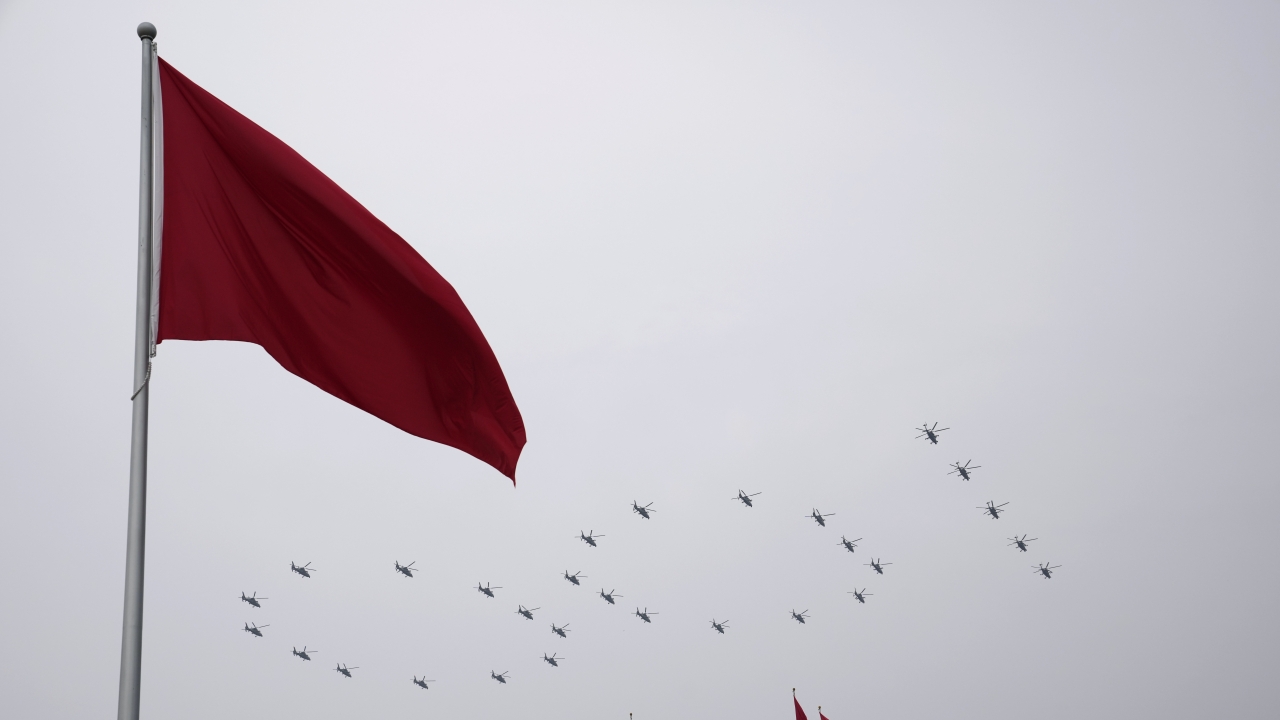 Helicopters fly over Chinese flags at Tiananmen Square in the formation of "100"