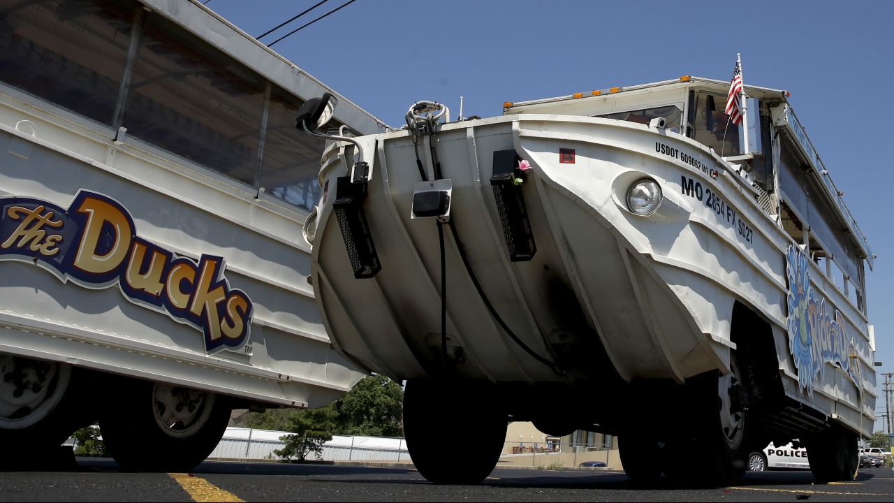 A man looks at an idled duck boat in the parking lot of Ride the Ducks