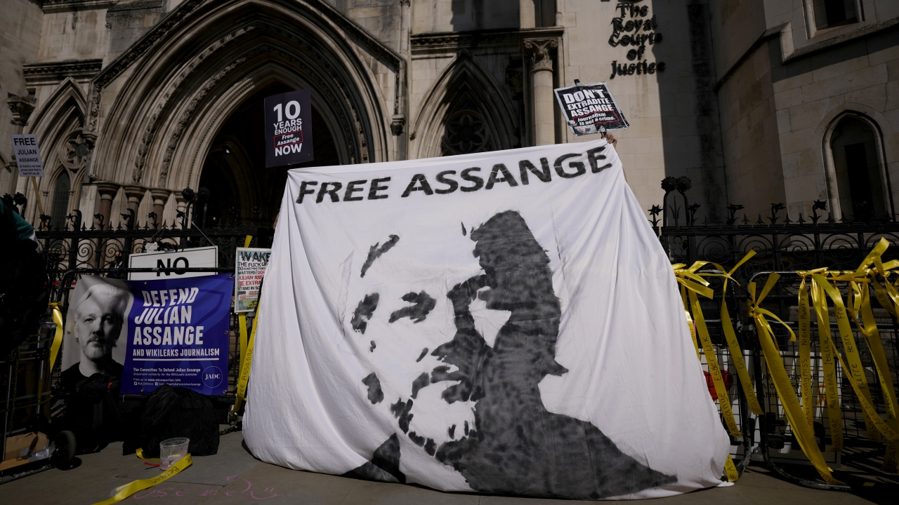 Supporters of WikiLeaks founder Julian Assange hold up a banner as they protest, during the first hearing in the Julian Assan