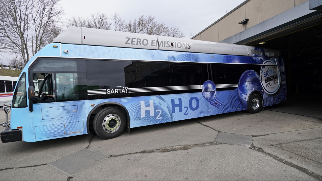 A maintenance technician, drives a hydrogen fuel cell bus out of the terminal